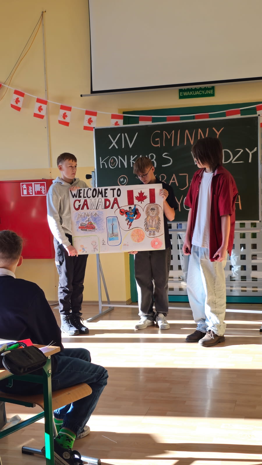 XIV GMINNY KONKURS WIEDZY O KRAJACH ANGLOJĘZYCZNYCH uczestnicy kokursu w trakcie prezentacji plakatu