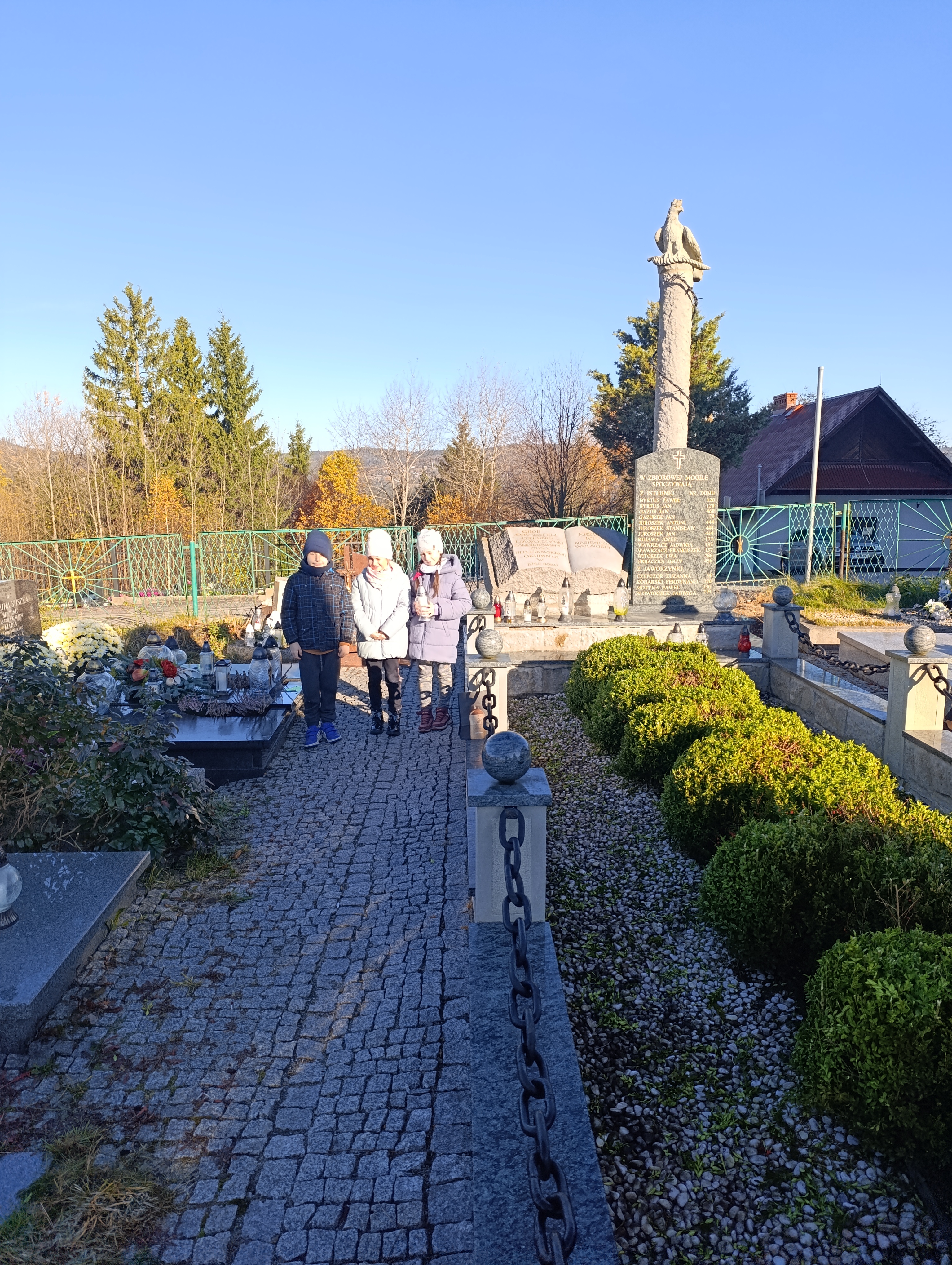 dzieci z kl. 3 zapalają znicz na zbirowej mogile