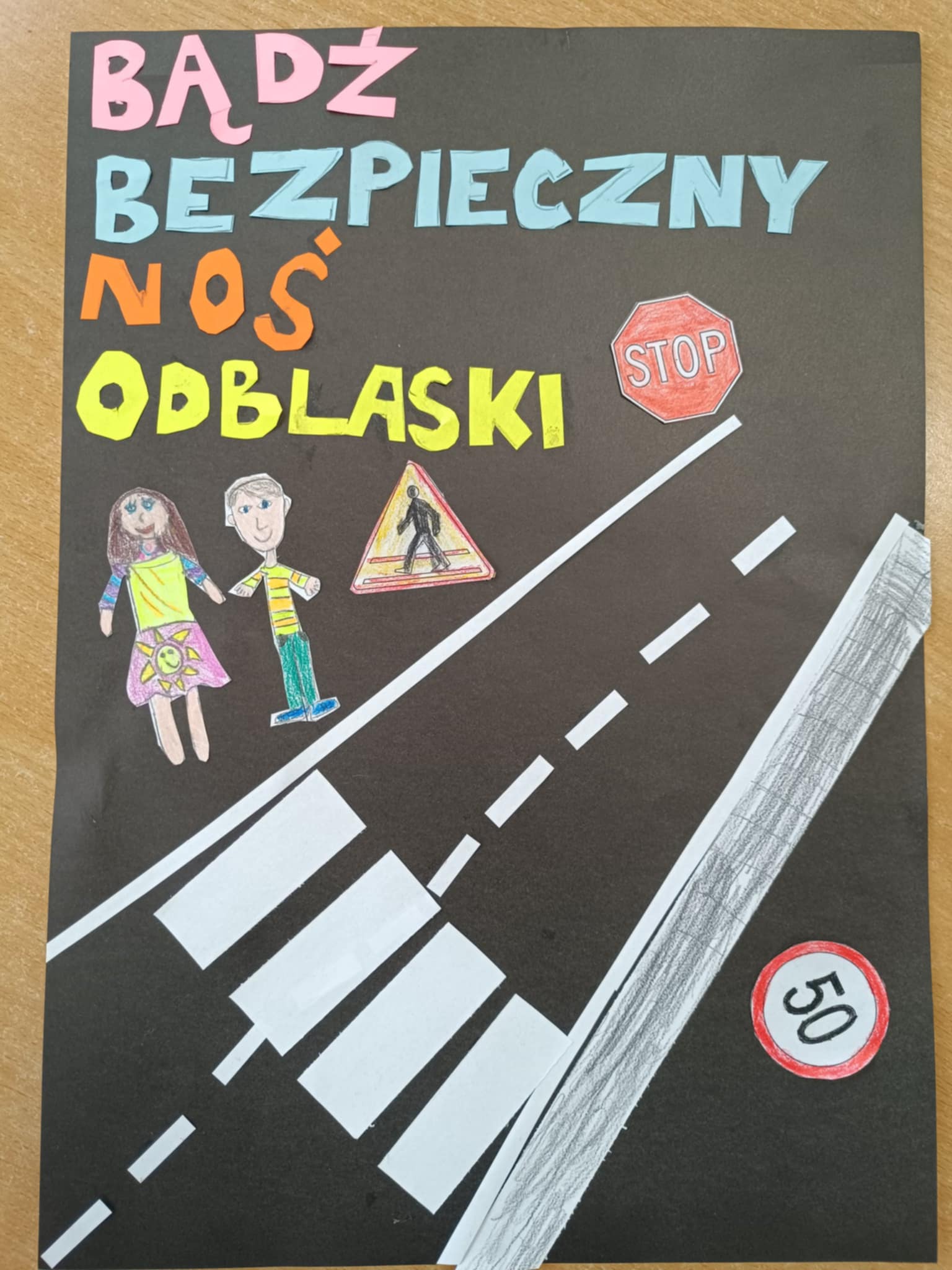 Plakat Bezpieczeństwo na drodze - kl. 2 zdjęcie plakatu pt. Bądź bezpieczny - noś odblasi" wykonany przez dzieci