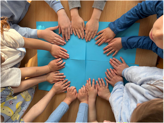 Światowy Dzień Świadomosci Autyzmu Ręce dzieci na niebieskich kartkach